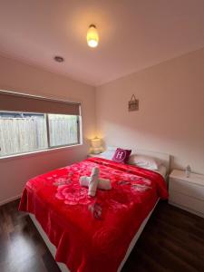 a bedroom with a red bed with a stuffed animal on it at My Home in Truganina