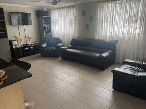 a living room with a leather couch and chairs at Imvubu Chalet in Sodwana Bay