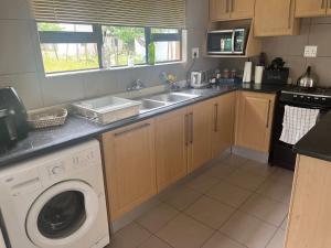 a kitchen with a sink and a washing machine at Imvubu Chalet in Sodwana Bay