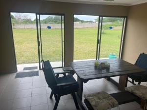 a dining room with a wooden table and chairs at Imvubu Chalet in Sodwana Bay +7 photos