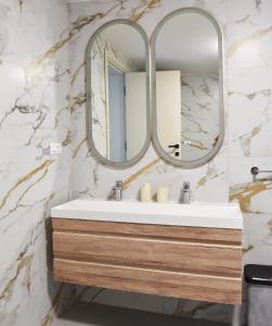 a bathroom with a sink and a mirror at Apartments and Rooms Tomas in Podstrana +139 photos