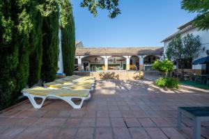 a row of chaise lounges on a patio at Alojamiento El Cortijuelo in Escóznar