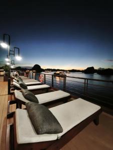 a row of benches with pillows on top of a boat at Cycad cruise in Ha Long