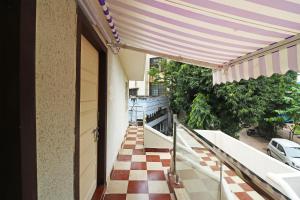 a balcony with awning and a checkered floor at Hotel O Krishna Hotel and Restaurant in Raipur
