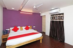 a bedroom with a large bed with a purple wall at Hotel O Krishna Hotel and Restaurant in Raipur