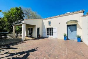 a white house with a large driveway at Villa paisible avec piscine in Bercloux