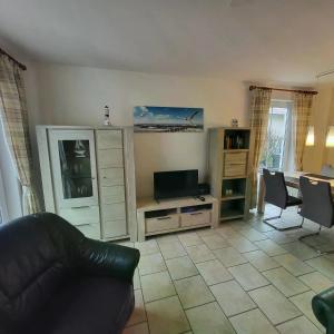 un salon avec un canapé et une télévision dans l'établissement Ferienhaus Pia, à Dorum Neufeld