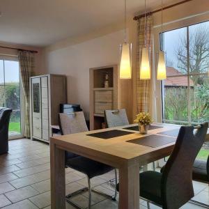 une salle à manger avec une table et des chaises en bois dans l'établissement Ferienhaus Pia, à Dorum Neufeld 18 autres photos