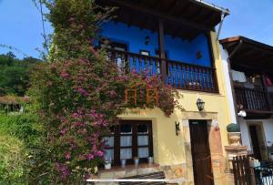 a building with purple flowers in front of it at 15A08 El Rosal By R2R in Buelna