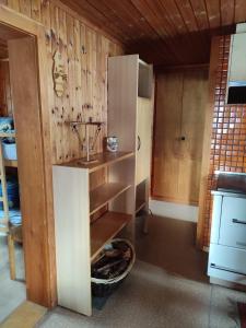 a kitchen with a shelf and a refrigerator in it at Chalet Lueg uf Belalp in Rosswald
