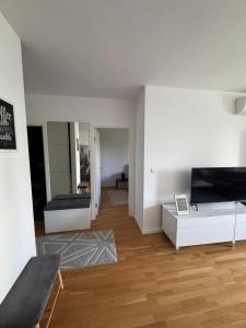 a white living room with a couch and a television at Apartman IsTar View in Sarajevo +1 photo