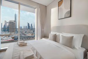 a bedroom with a large white bed and a large window at Vida Dubai Mall! 2 Bedroom with Burj Khalifa View! Direct Access to Dubai Mall in Dubai