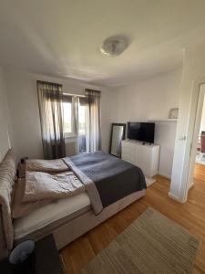 a bedroom with a large bed and a television at Apartman IsTar View in Sarajevo