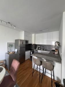 a kitchen with a counter and some chairs in it at Apartman IsTar View in Sarajevo