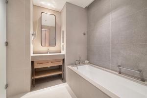 a bathroom with a tub and a sink and a mirror at Vida Dubai Mall! 2 Bedroom with Burj Khalifa View! Direct Access to Dubai Mall in Dubai +73 photos