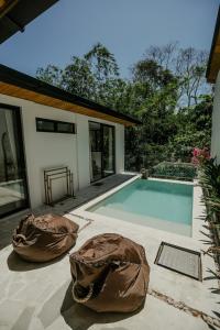 a swimming pool with two cushions next to a house at Villa Tamu 3 in Bingin Beach