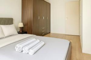 a bedroom with a white bed with towels on it at Cozy Marquette apartment 10 min from Lille center in Marquette-lès-Lille