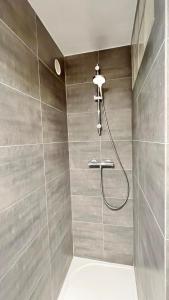 a bathroom with a shower with a shower head at Cozy Marquette apartment 10 min from Lille center in Marquette-lès-Lille