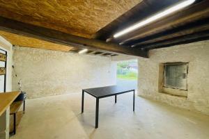 ein Raum mit einem schwarzen Tisch in der Mitte in der Unterkunft Maison les mottes-cour et garage in Asnières-la-Giraud