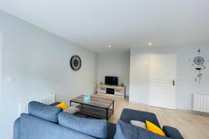 ein Wohnzimmer mit einem blauen Sofa und einem Tisch in der Unterkunft Maison les mottes-cour et garage in Asnières-la-Giraud