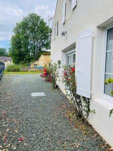 ein Haus mit Blumen an der Seite in der Unterkunft Maison les mottes-cour et garage in Asnières-la-Giraud