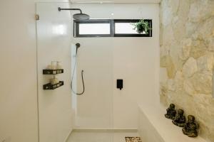 a shower with a glass door in a bathroom at Villa Tamu 3 in Bingin Beach +21 photos