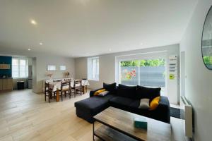 ein Wohnzimmer mit einer schwarzen Couch und einem Tisch in der Unterkunft Maison les mottes-cour et garage in Asnières-la-Giraud + 18 Fotos