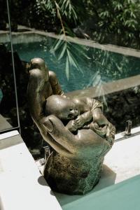 a statue of a woman and a child sleeping at Villa Tamu 3 in Bingin Beach