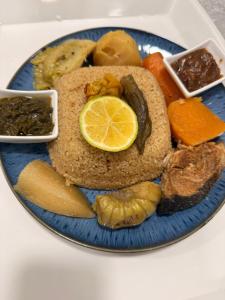a blue plate of food with vegetables on a table at Chambres d'Hôtes Centre Ville in Dakar