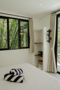 a bedroom with a bed and a large window at Villa Tamu 3 in Bingin Beach