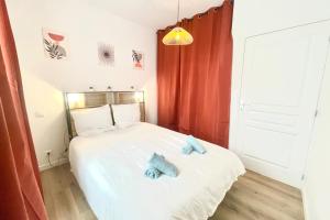 a bedroom with a bed with two blue pillows on it at Le Saintonge avec climatisation in Saintes