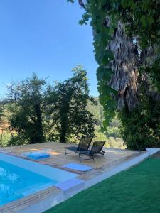 a couple of chairs sitting next to a swimming pool at La casita del oso in Linares de la Sierra