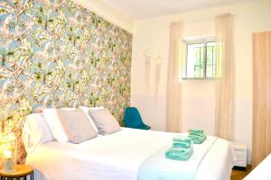 a bedroom with a white bed with a floral wallpaper at La casita del oso in Linares de la Sierra