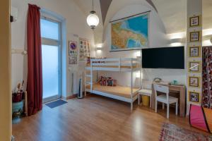 a bedroom with two bunk beds and a desk and a tv at Fore te capu casavacanze Lecce in Lecce