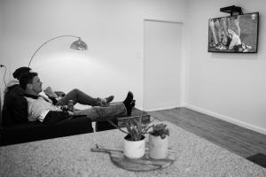 a man sitting on a couch in a living room at Island Quarters in Whitemark