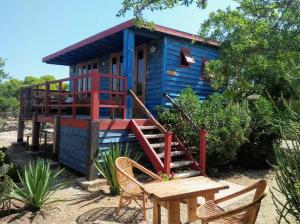 a blue tiny house with a table and chairs at Bed0Bled Cabanes & Holiday homes in Sidi Kaouki