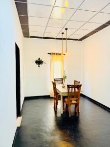 a dining room with a table and two chairs at Sigiri Bloom Villa in Sigiriya