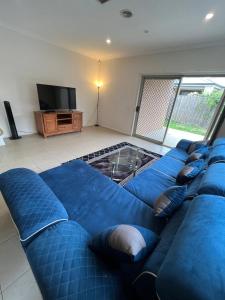 a large blue couch in a living room with a television at My Home in Truganina