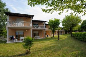 a large house with a yard in front of it at Ohana Apartments Camping Tiglio in Sirmione