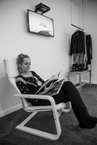 une femme assise sur une chaise dans une pièce dans l'établissement Island Quarters, à Whitemark