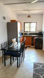 una cucina con tavolo, sedie e frigorifero di Treasured Haven Stay a Ukunda