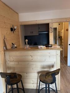 een keuken met 2 stoelen en een aanrecht in een kamer bij Studio tout confort in Barcelonnette