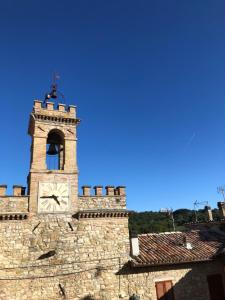 a building with a clock tower on top of it at La Piazzetta Apartment in Pietralunga