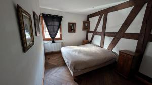 een kleine slaapkamer met een bed en een spiegel bij Les Perles du Ried - Gîte 201 in Boofzheim