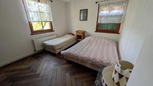 een kleine kamer met 2 bedden en 2 ramen bij Les Perles du Ried - Gîte 201 in Boofzheim +19 foto's