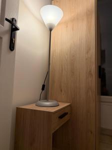 a lamp sitting on top of a wooden cabinet at Maison Bon Séjour in Livry-Gargan
