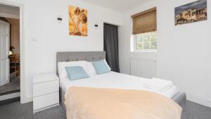 une chambre blanche avec un lit et une fenêtre dans l'établissement Regalia Living Apartment in Southampton, à Southampton