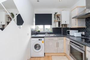 une cuisine avec une machine à laver et un évier dans l'établissement Regalia Living Apartment in Southampton, à Southampton