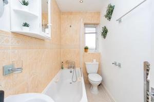 une salle de bain avec une baignoire, des toilettes et un lavabo dans l'établissement Regalia Living Apartment in Southampton, à Southampton 11 autres photos