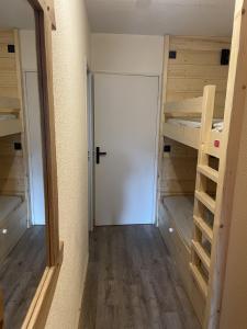 een kamer met 2 stapelbedden en een deur bij Studio tout confort in Barcelonnette
